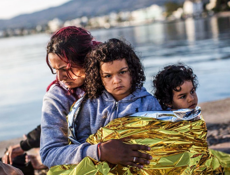 A Syrian family waits after being escorted into the harbor by the Greek Coast Guard, which found them drifing offshore on June 4, 2015, in Kos, Greece.