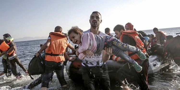 A Syrian migrant holds a young girl in his arms upon arriving on a dinghy to the Greek island of Kos, Greece.(EPA/Yannis Kolesidis)