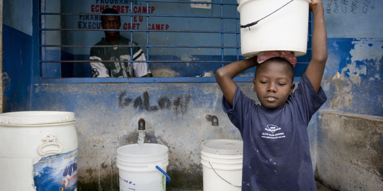 A boy buys water at a distribution point in Cite L'Eternel, a poor neighborhood of Port au Prince. UNICEF, through the NGO Gret, distributes thousands of aqua-tabs to the Haitian population to respond to the cholera outbreak that killed over 1000 people.