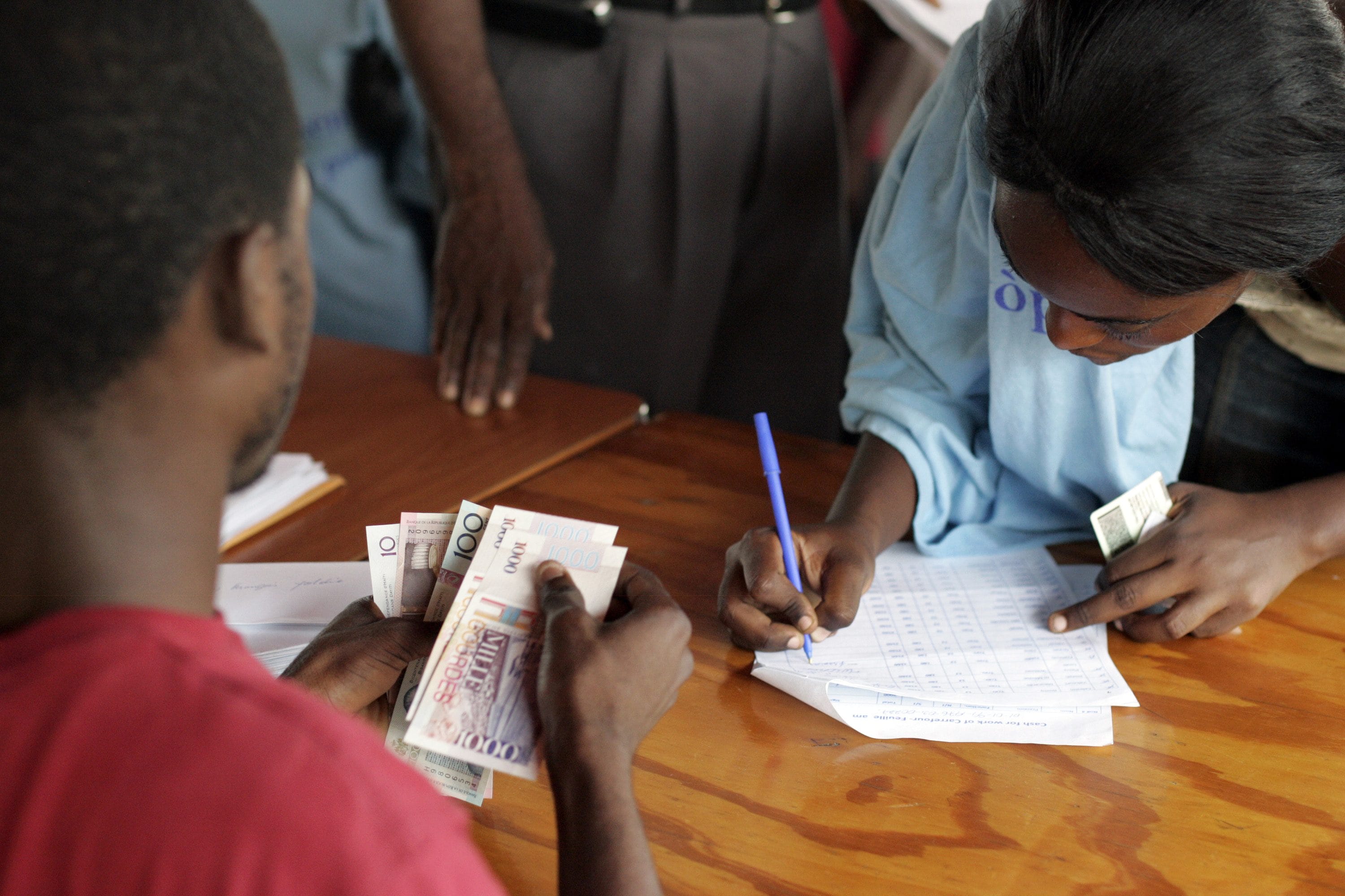 1500 workers in UNDP's Cash for Work program get paid every 15 days at the Sant Triyaj Fatra in the Kafoufey neighborhood of Port-au-Prince after which they cannot work for the program again as there is a 6000 person waiting list to become a street cleaner. Each worker is paid a little over minimum wage at 180 Haitian Gourdes per day.