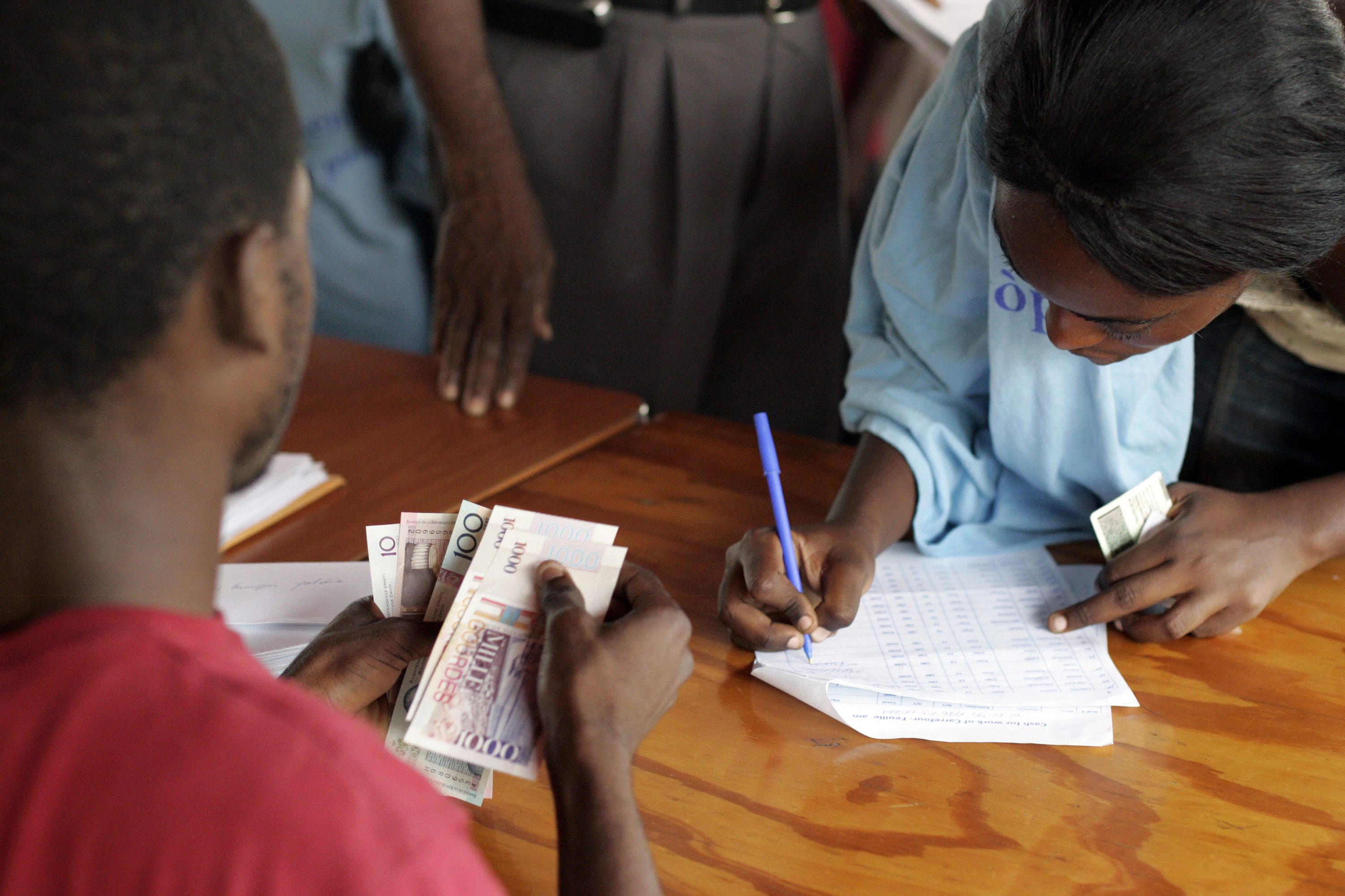 1500 workers in UNDP's Cash for Work program get paid every 15 days at the Sant Triyaj Fatra in the Kafoufey neighborhood of Port-au-Prince after which they cannot work for the program again as there is a 6000 person waiting list to become a street cleaner. Each worker is paid a little over minimum wage at 180 Haitian Gourdes per day.