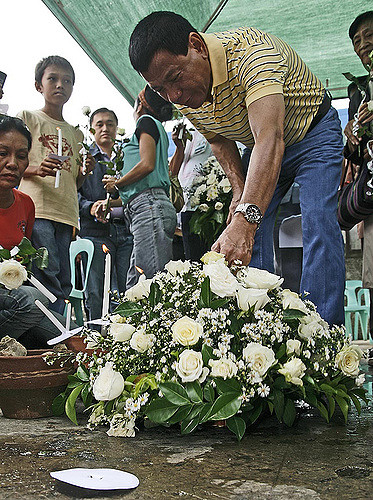 Mayor Duterte placing flowers at the Davao International Airport in 2009 to commemorate the 6-year anniversary of the bombing there. Photo Credit: Kieth B. via Flickr. 
