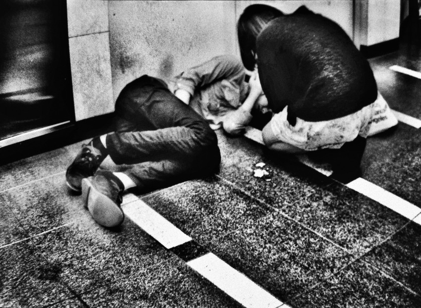 A girl tries to help her heavily drunk boyfriend who collapsed in an alley in Shinjuku. Early evening hard drinking is a widespread habit among the often depressed young generation in Tokyo.