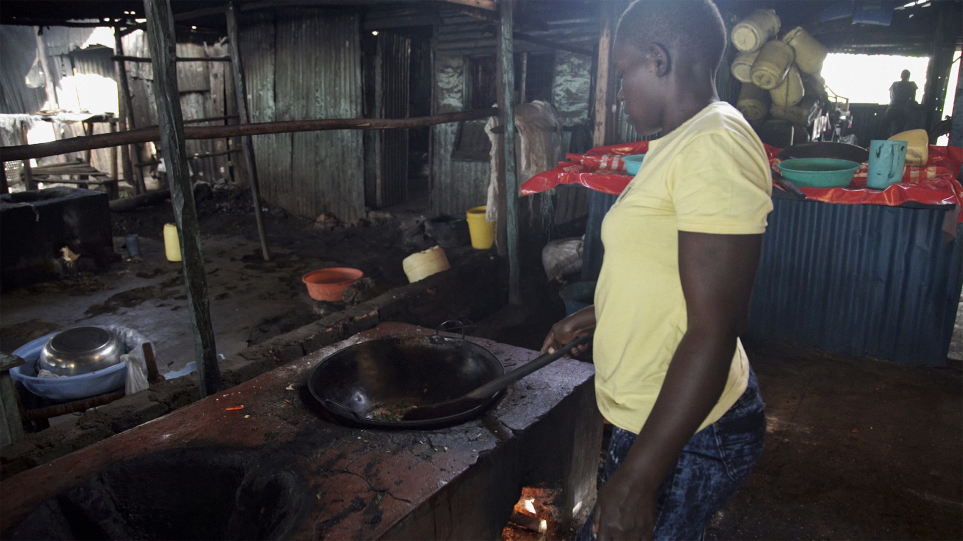 A cook prepares food in her restaurant on a recently installed rocket stove on the shores of Lake Victoria in Kisumu, Kenya. The rocket stoves are cleaner and more effiecient, allowing restaurants to expand and serve more customers. Photo: Petr Kapuscinski / World Bank