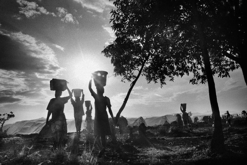 Displaced people bring back water to their camp in Goma after fleeing fighting in Karuba and Mushake. Fighting rages between government forces and rebels in Karuba, North Kivu province.