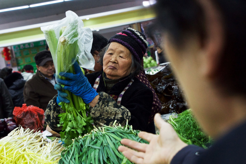 05 March 2016, Beijing, China - Shoppers and vendors handling produce at a local market near Beijing's Lucky Street.