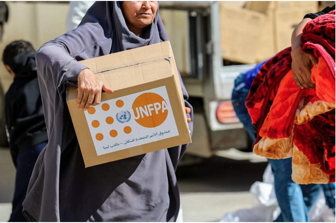 A woman, internally-displaced by the conflict in Tripoli, holds a dignity kit containing essential items for her hygiene.