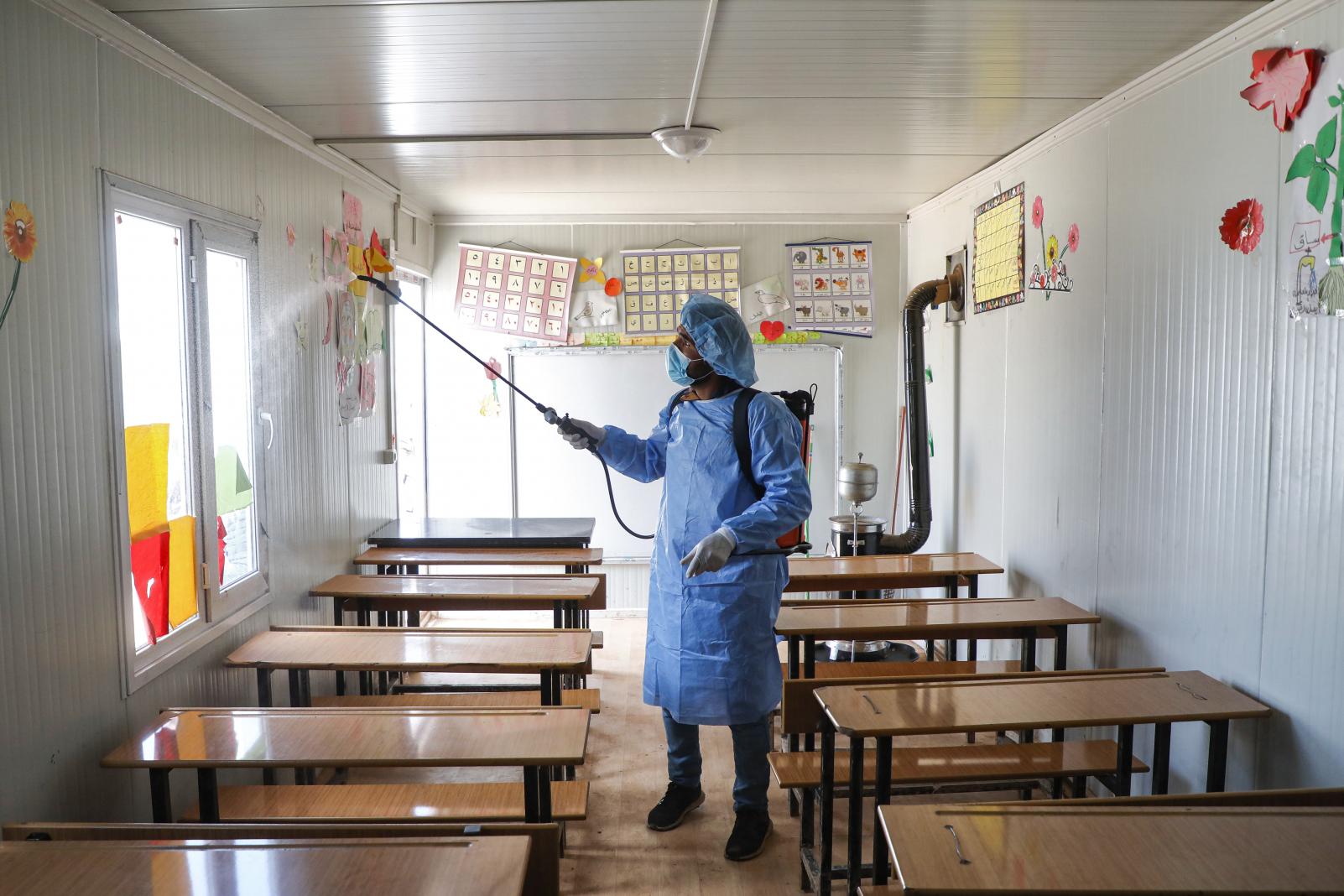 A man disinfecting an empty classroom once the school was closed.
