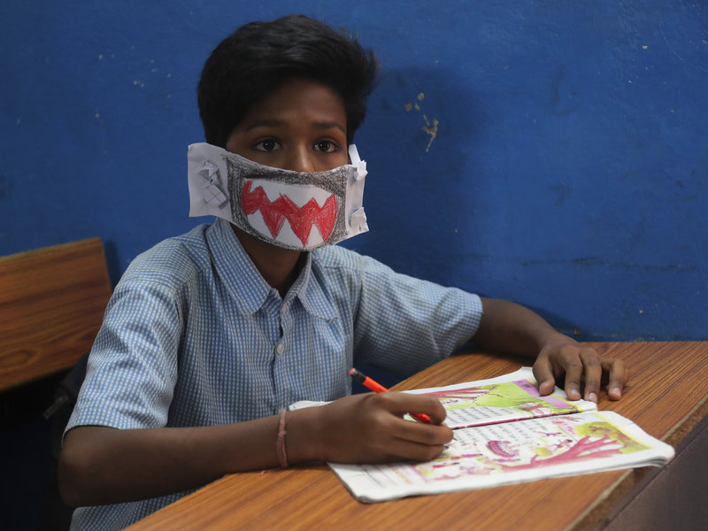 A child wears a self-made mask to in an Indian school.