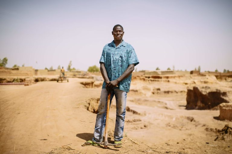 Gold miner posing with pick axe tool.