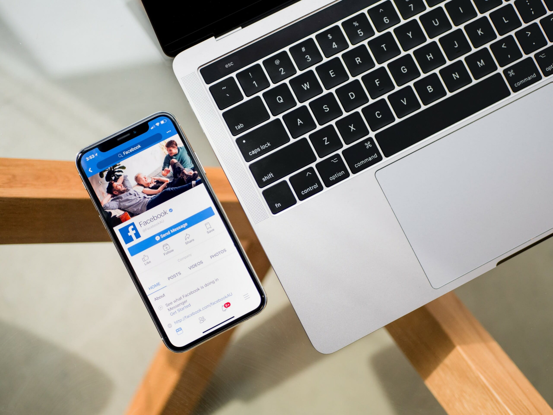 Phone beside a computer displaying Facebook