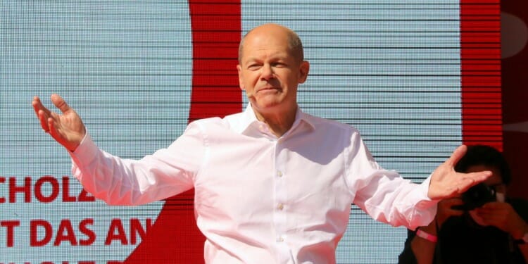 man on stage opening arms