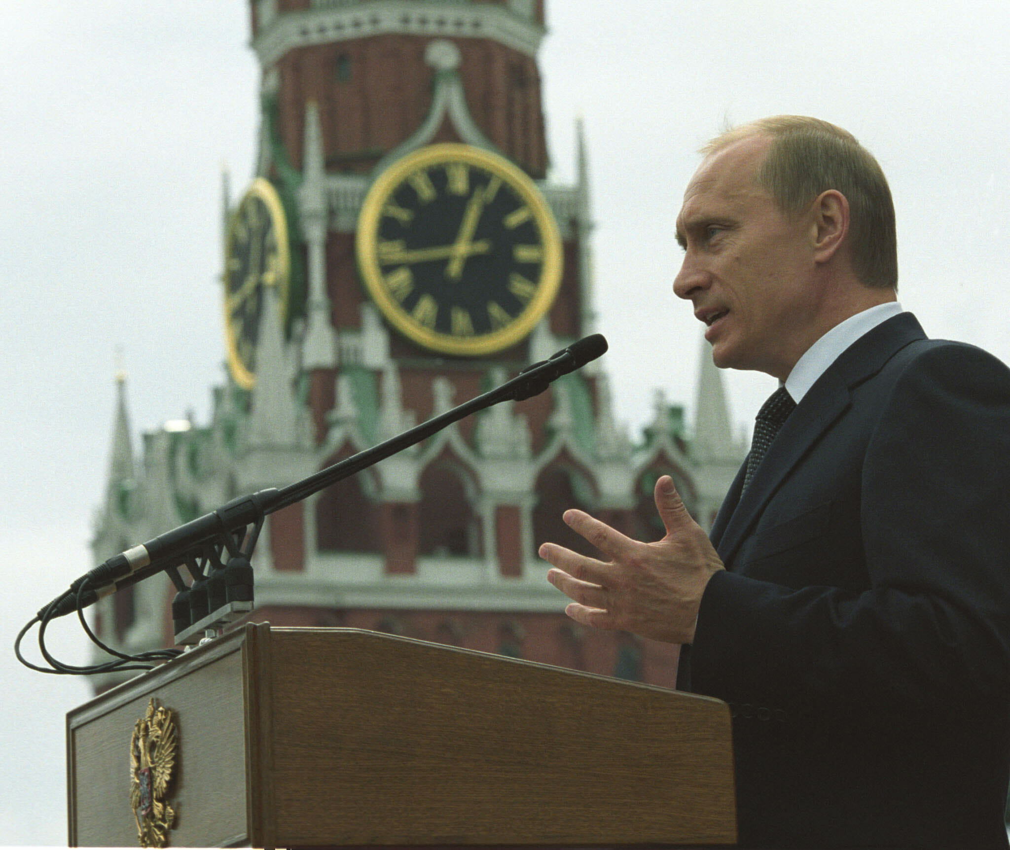 man speaking on stage to a microphone
