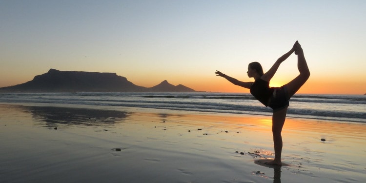 Person doing yoga on the beach at sunset Credit: Gary Skirrow Via Pixabay