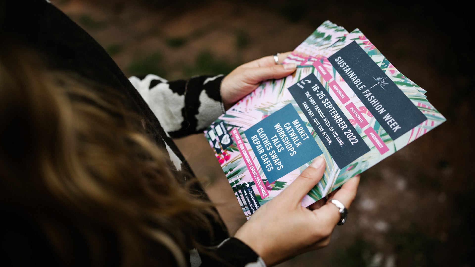 Woman holding Sustainable Fashion Week Leaflets.