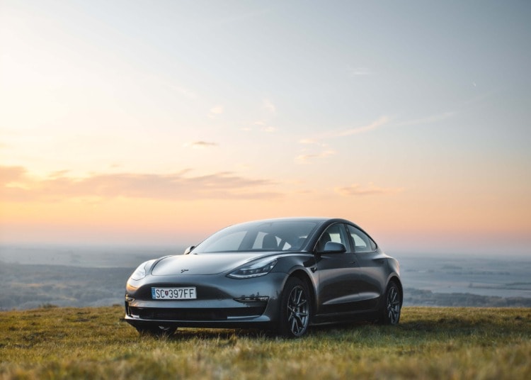 Electric car on a cliff at sunset