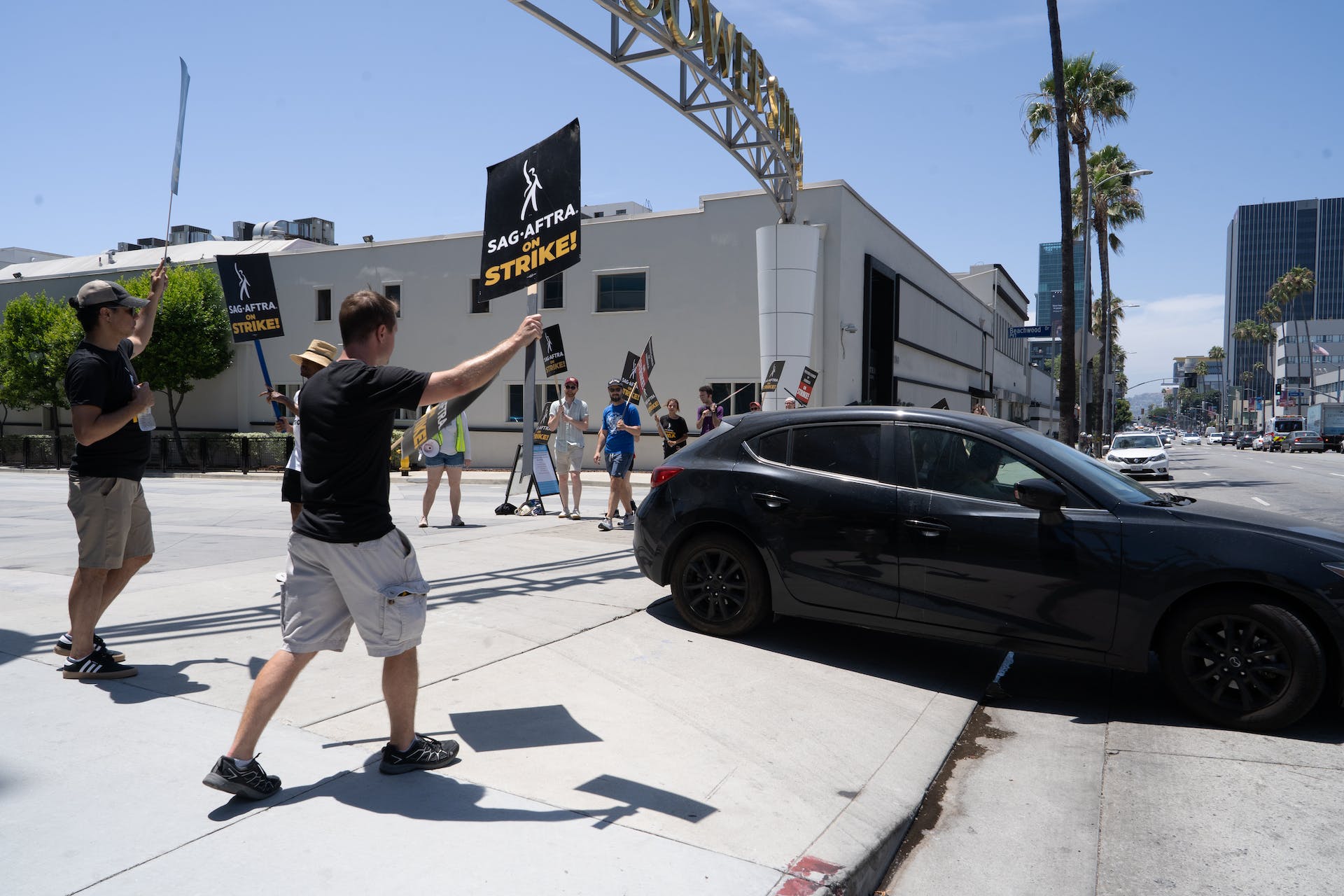 SAG-AFTRA union members on strike, walking down a road.