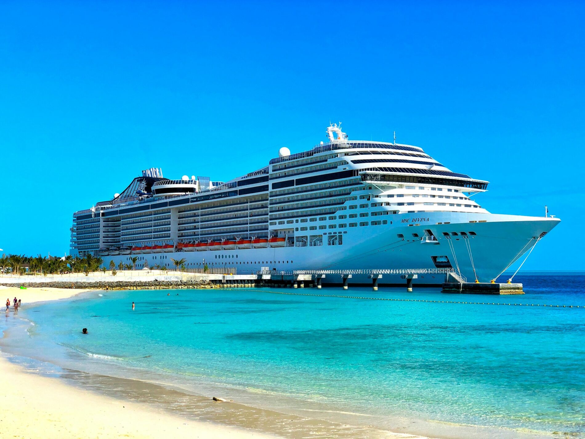 A large white cruise ship docked at a port.