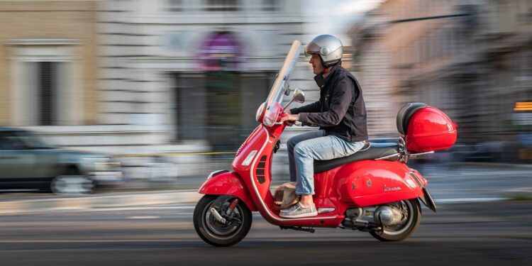 Bike Insurance: red Piaggio vespa riding in Rome