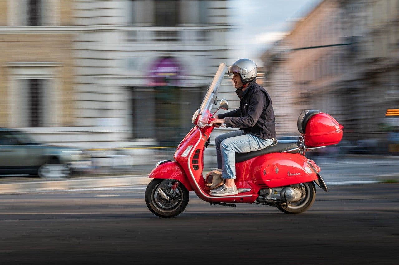 Bike Insurance: red Piaggio vespa riding in Rome