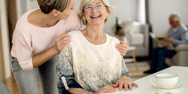 Home Care Support: Cheerful senior woman having fun with her adult daughter at home