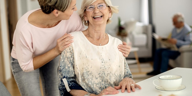 Home Care Support: Cheerful senior woman having fun with her adult daughter at home