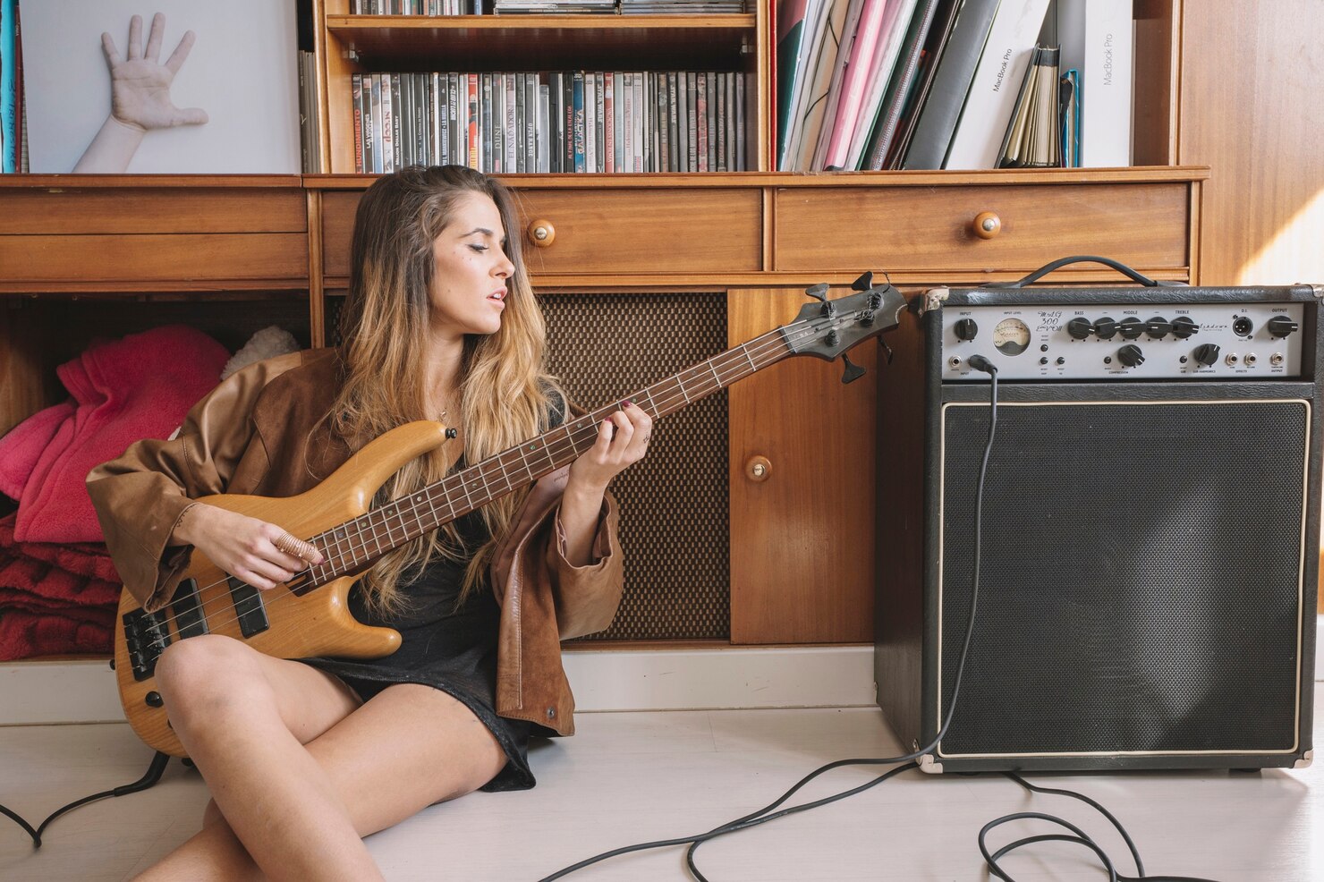 Woman playing an Electro-Acoustic Guitar and adjusting as she goes along.