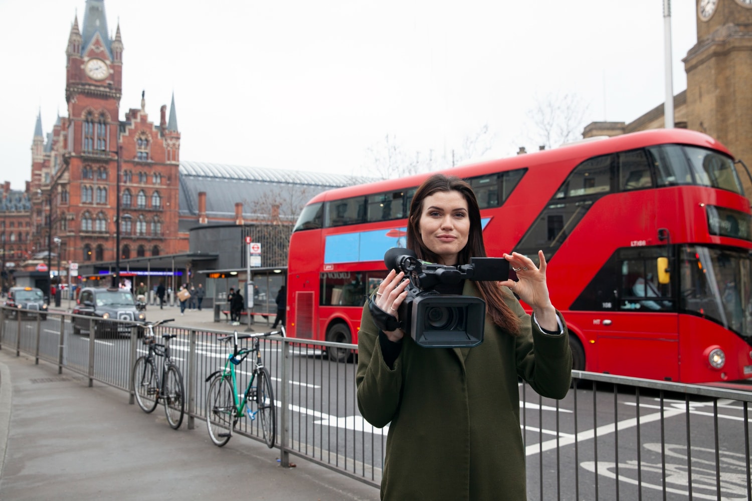 Content production in London - Woman standing with a camera in front of Westminster.